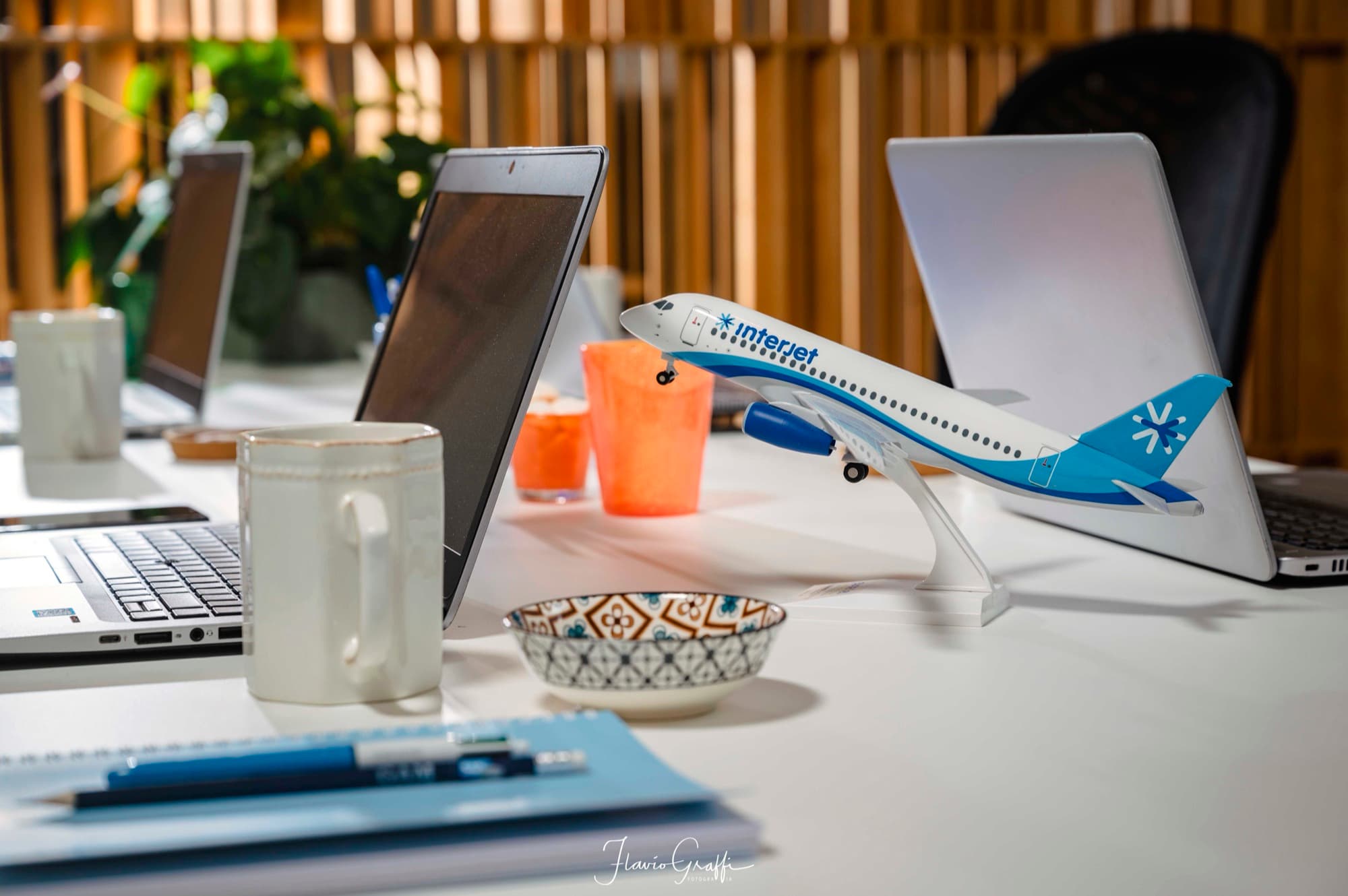 A desk in the GAM office with laptops and a model aeroplane