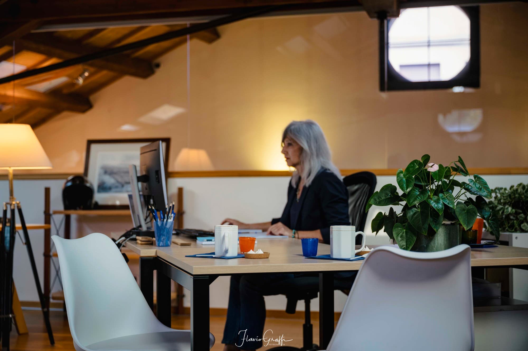 A colleague at work in the office with exposed wooden beams